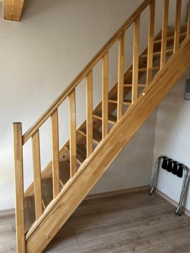 a wooden staircase with a dog sitting under it at Hotel Colosseum in Rheinböllen