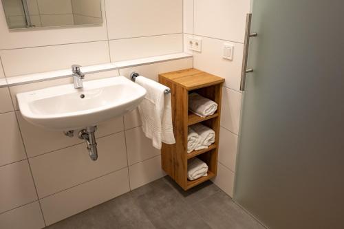 a bathroom with a sink and a shelf with towels at HeindlHof in Ingolstadt