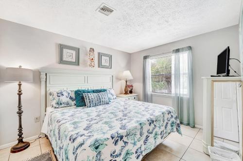 ein Schlafzimmer mit einem Bett, einem Fernseher und einem Fenster in der Unterkunft Blissful Beach Retreat B in Englewood
