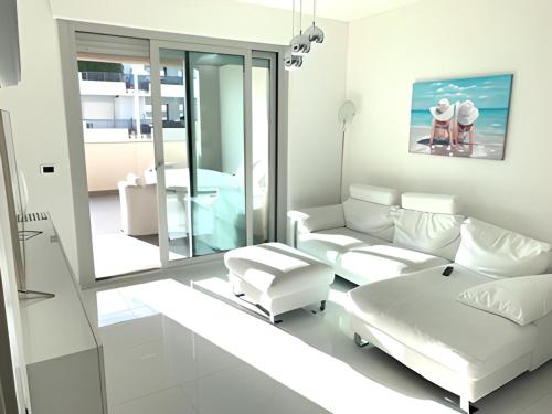 uma sala de estar branca com um sofá e uma mesa em La Suite sul Mare 1 em Montesilvano