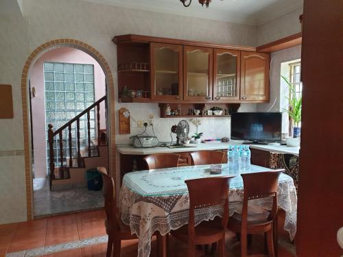 een keuken met een tafel en stoelen en een keuken met een trap bij Lavender Impian Homestay in Kajang