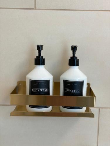 two bottles of soap on a shelf in a bathroom at Pure Berlin Apartments - Luxury at Pure Living in City Center in Berlin