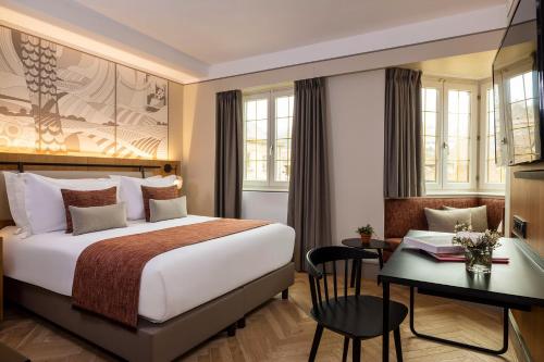 a hotel room with a bed and a desk at Hotel La Diligence in Obernai