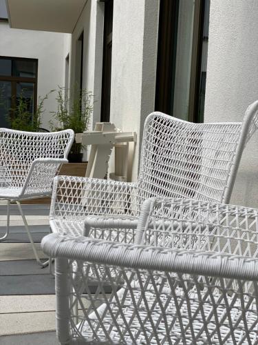 two white wicker chairs sitting on a porch at Pure Berlin Apartments - Luxury at Pure Living in City Center in Berlin