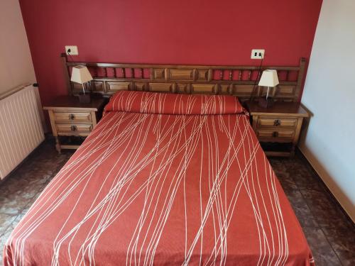 a bedroom with a bed and a red wall at Hostal Las Vegas in Cangas de Morrazo