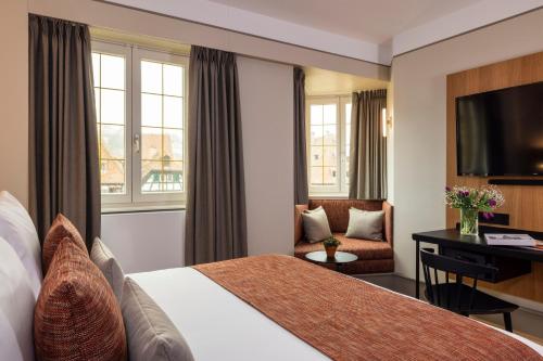 a hotel room with a bed and a desk at Hotel La Diligence in Obernai