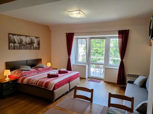 um quarto com uma cama e uma grande janela em Bohemica Apartments em Děčín