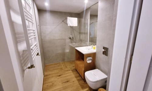 a bathroom with a white toilet and a sink at Prywatne apartamenty w hotelu - 365PAM in Sarbinowo