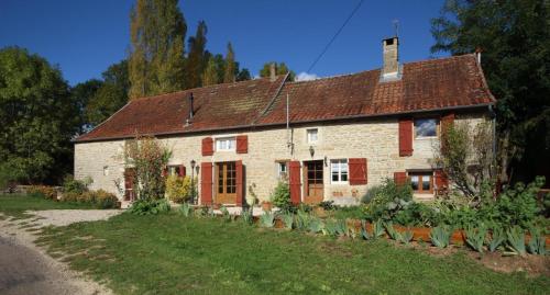 an old brick house with red shutters and a yard at Fleurey la Cabotaine in Mont-Saint-Jean