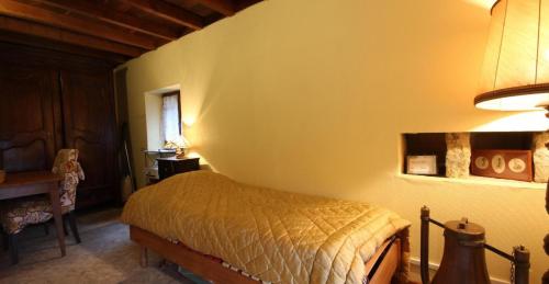 a bedroom with a bed in the corner of a room at Fleurey la Cabotaine in Mont-Saint-Jean