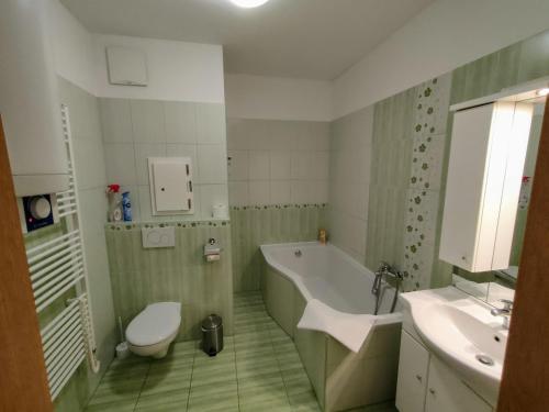 ein Badezimmer mit einer Badewanne, einem WC und einem Waschbecken in der Unterkunft Bohemica Apartments in Děčín
