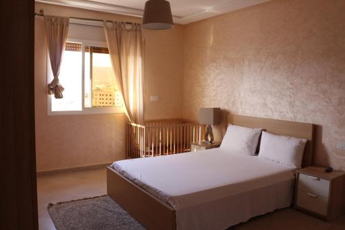 a bedroom with a white bed and a window at Panorama Apartment Nador Jadid Klima free Parking & Wifi in Nador