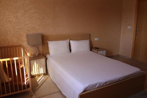 a bed with white sheets and pillows in a bedroom at Panorama Apartment Nador Jadid Klima Parking Only Family in Nador