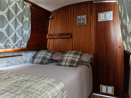 um quarto com uma cama num barco em Narrow Escape - 50ft Boat on the Grand Union Canal, near Tring em Tring