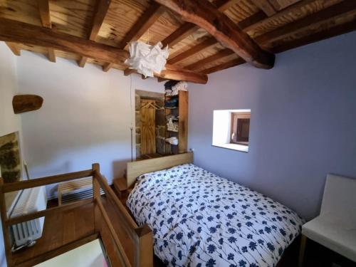 a bedroom with a bed in a room with wooden ceilings at Torre Tanquián Eco Finca - Ribeira Sacra in Pantón