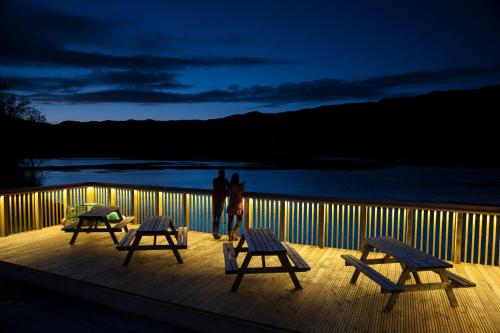 a person standing on a deck with three benches at Kylesku Hotel in Kylestrome