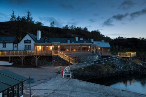 a house on a bridge over a body of water at Kylesku Hotel in Kylestrome