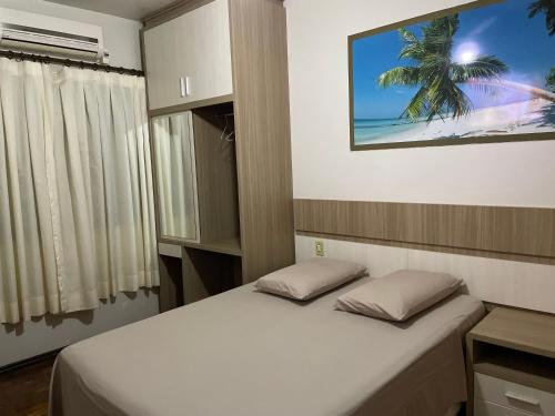 1 dormitorio con 1 cama con 2 almohadas en Marca Hotel, en Nova Santa Medianeira