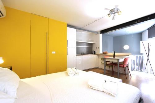 a bedroom with a bed and a kitchen with a table at Mono in Modica