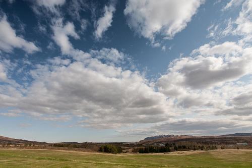 a large open field with a cloudy sky at Ljosafoss Lake Guest House in Selfoss