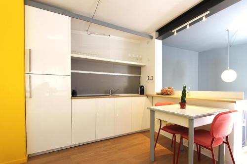 a kitchen with white cabinets and a table and chairs at Mono in Modica