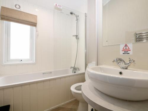 Un baño con lavabo, inodoro y bañera. en Lodge at Chichester Lakeside 3 Bed, en Chichester