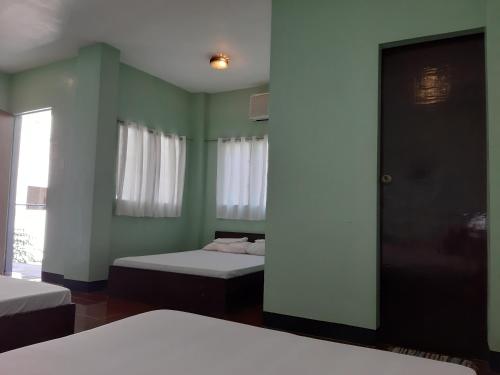 a room with two beds and a window at Angel and Marie's Basic ACroom for 3-6 pax in San Juan