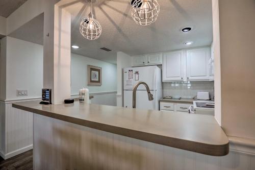 a kitchen with white cabinets and a large counter top at Colorful Oceanside Condo with Beach Access! in Saint Augustine Beach