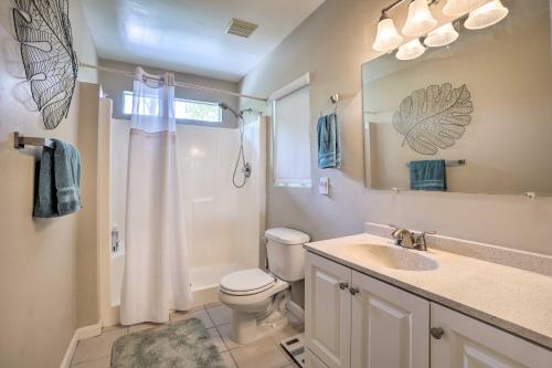 La salle de bains est pourvue de toilettes, d'un lavabo et d'un miroir. dans l'établissement Pet-Friendly Waterfront Home - 2 Mi to Beach!, à Tarpon Springs