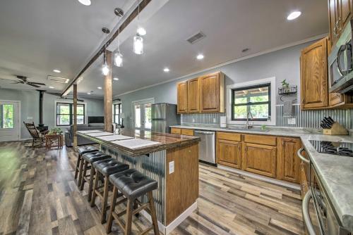a large kitchen with wooden cabinets and bar stools at Peaceful Guest Home with Patio on 152-Acre Farm in Berger