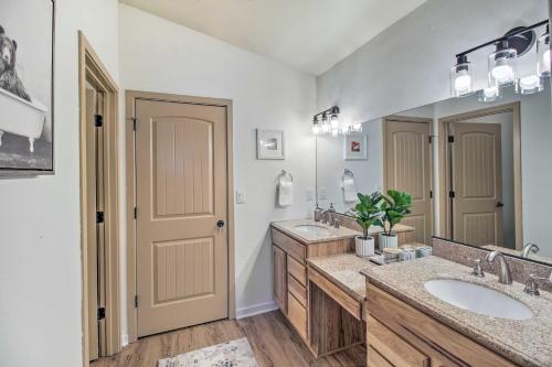 La salle de bains est pourvue de 2 lavabos et d'un grand miroir. dans l'établissement Lakeside Cabin with Game Room and Private Dock!, à Lake of the Woods
