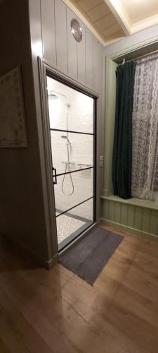 uma porta que dá acesso a um quarto com uma casa de banho com um chuveiro em B en B Op Steendam, Het Voorhuis em Steendam
