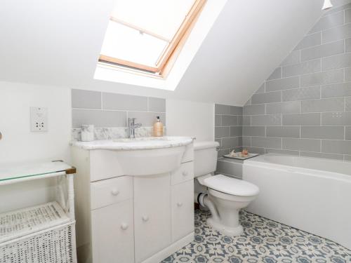 ein Badezimmer mit einem Waschbecken, einem WC und einem Dachfenster in der Unterkunft Hurst Green in Ewyas Harold