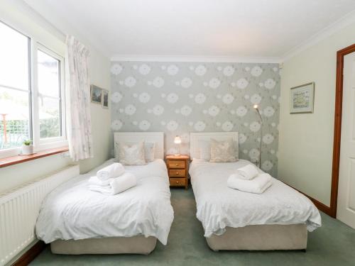 2 Einzelbetten in einem Zimmer mit 2 Fenstern in der Unterkunft Hurst Green in Ewyas Harold