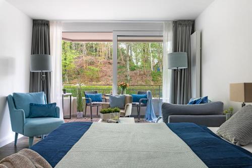 a bedroom with a bed and chairs and a patio at Strandnest in Glücksburg