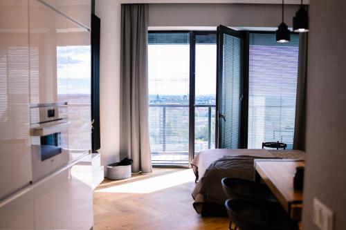 een slaapkamer met een bed en een groot raam met uitzicht bij Hanza Tower City View in Szczecin