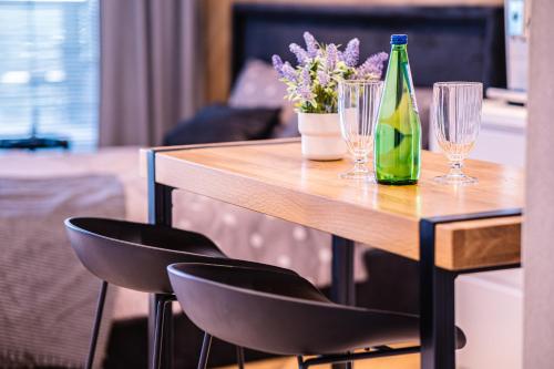 una mesa de madera con 2 copas y una botella de vino en Hanza Tower City View 13th floor, en Szczecin