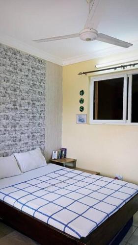 een slaapkamer met een bed en een raam bij Nimo - One Bedroom Beachroad Deluxe Apartment, Mtwapa in Mombasa
