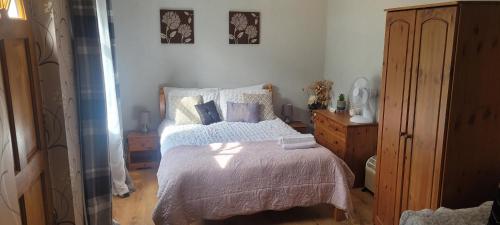 a bedroom with a bed with white sheets and pillows at Eskdale in Woolton