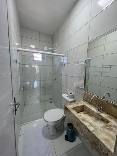Un baño con inodoro, lavabo y ducha. en Pousada Praia Bela, en Maragogi