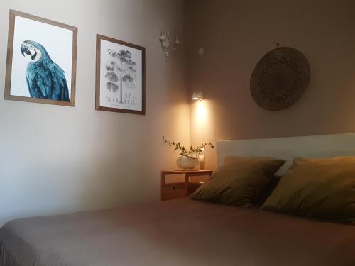 a bedroom with a bed and two pictures on the wall at Green Rock Villa - gardens, playground and close to beach! in Agios Gordios