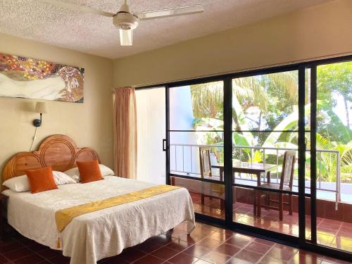 a bedroom with a bed and a view of a balcony at Hotel Alegria in Cabarete