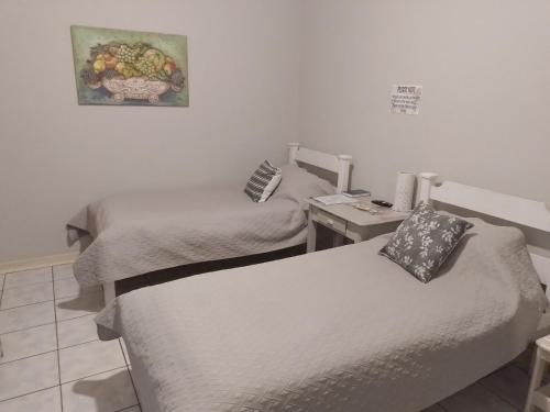 a room with two beds and a desk with a picture on the wall at Larochelle Guesthouse in Keetmanshoop