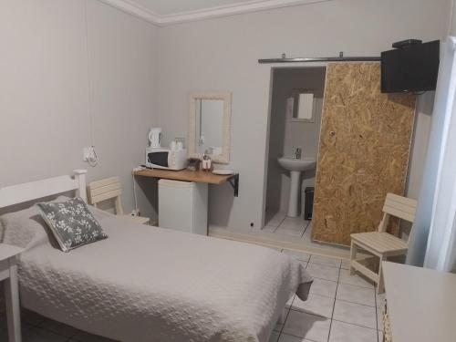 1 dormitorio con 1 cama y baño con lavamanos en Larochelle Guesthouse en Keetmanshoop