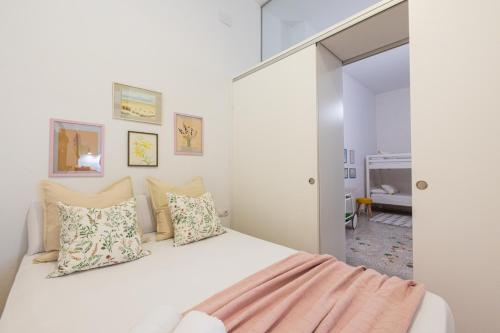 - une chambre avec un lit blanc et des oreillers dans l'établissement FLORIT FLATS - Traditional House in El Cabanyal, à Valence