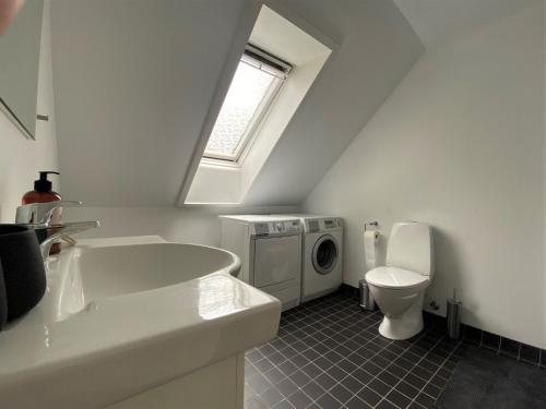 uma casa de banho com um lavatório, um WC e uma janela. em ApartmentInCopenhagen Apartment 1470 em Copenhague