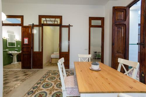 a dining room with a wooden table and a bathroom at FLORIT FLATS - Traditional House in El Cabanyal in Valencia