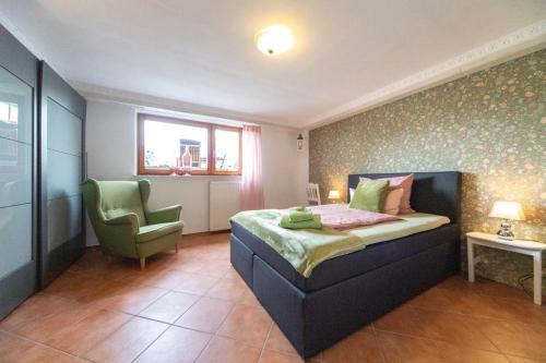 1 dormitorio con 1 cama y 1 silla verde en Kajüte, en Ihlow