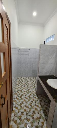 a bathroom with a shower with a sink and a toilet at Khmer House Guesthouse in Kep