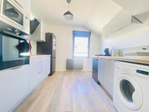 une cuisine avec un lave-linge et un lave-linge dans l'établissement Appartement spacieux et élégant, à Laon